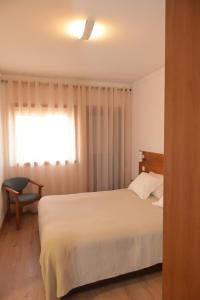 马塞杜-迪卡瓦莱鲁什Casa Das Eiras的卧室配有白色的床和窗户。