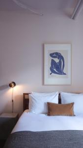 蒙特利尔Maison Saint-Vincent By Maisons & co的一间卧室配有一张带白色床单和照片的床