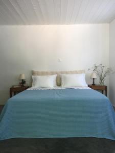 KórinthosAνεξάρτητη παραδοσιακή πέτρινη κατοικία的一间卧室配有蓝色的床和2个床头柜