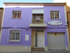 Bolaños de CalatravaLa Morada Casa Rural的紫色的房子设有阳台和门