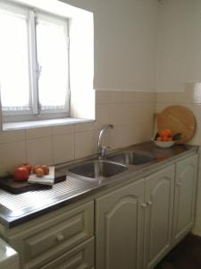 KórinthosAνεξάρτητη παραδοσιακή πέτρινη κατοικία的带两个水槽和两个窗户的厨房