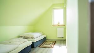 利马诺瓦Domek POD GOLCOWEM的带窗户的客房内设有两张单人床。