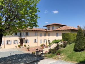 卡内利Agriturismo La Casa in Collina的一座巨大的棕褐色建筑,前面有一棵树