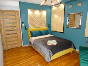 布尔日APPARTEMENTY COCO MANGO的一间卧室配有一张蓝色墙壁的床