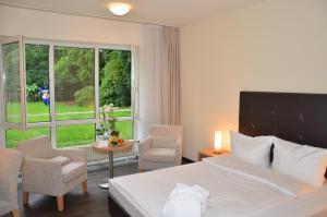 陶努斯山区克龙贝格维多利亚康库德酒店的酒店客房带一张床、一张桌子和椅子