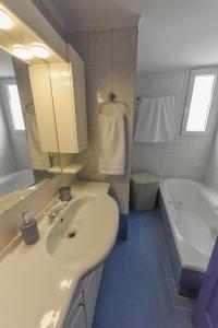 库卡里DEJA BLUE Maisonette ll的浴室配有盥洗盆、浴缸、盥洗盆和镜子