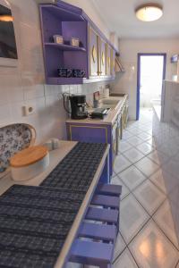 库卡里DEJA BLUE Maisonette ll的厨房配有紫色橱柜和台面