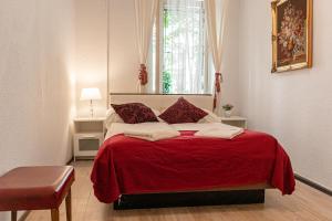 维也纳Timeless Red 1BR Apartment - Great for Longstays的一间卧室配有红色的床和红色毯子