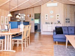 海默特4 star holiday home in Hemmet的厨房以及带桌子和蓝色沙发的客厅。