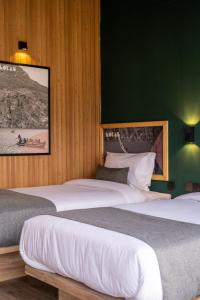 BaltitLOKAL Rooms x Hunza (5 Peaks)的一间卧室设有两张床和绿色的墙壁