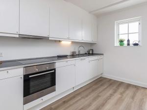 巴恩科普8 person holiday home in Bagenkop的白色的厨房配有白色橱柜和窗户