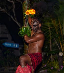 辛加东卡Likuri Island Resort Fiji的戴面具的男子拿着一朵花