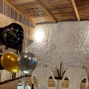 科韦尼亚斯Hotel Cabaña Playa DanRay的一张桌子,上面放着气球和瓶装葡萄酒