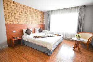 素叻CBD素拉泰尼酒店的一间卧室设有一张大床和一个窗户。