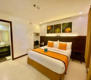 长滩岛乔伊海滩度假村的一间卧室配有一张带橙色枕头的大床