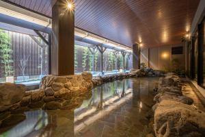 京都Kyoto Umekoji Kadensho的一座建筑中一座带岩石的大型室内游泳池