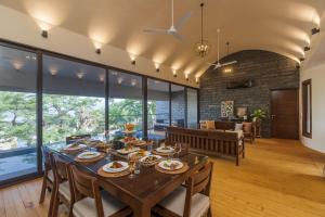 罗纳瓦拉SaffronStays Yahvi Waters by Kosha Villas, Pawna - pool villa with stunning lake view的用餐室以及带桌椅的起居室。