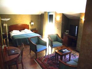 库尼奥Hotel Palazzo Lovera的配有床、椅子和桌子的酒店客房