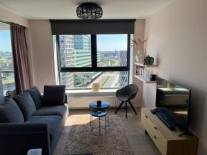 安特卫普"VH apartment" - center of Antwerp - free parking的客厅设有蓝色的沙发和大窗户