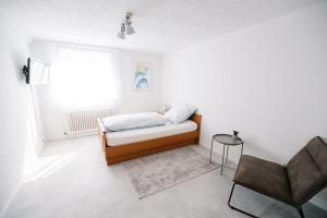 FrickenhausenGasthof Löwen的白色的小房间,配有床和椅子