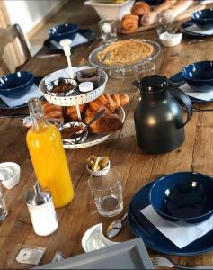 PiennesLes Chambres d'hotes de Sophie的一张带早餐食品和橙汁的木桌
