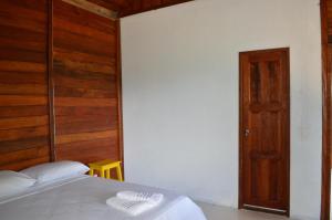 菲格雷多总统镇Aldeia Mari-Mari Amazon Lodge的一间卧室设有一张床和木墙