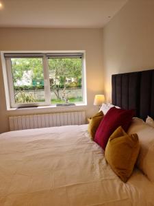 基拉尼Ard Kielin Apartment Luxury 2 bedroom in Killarney的一间卧室配有一张大床,提供黄色和红色枕头