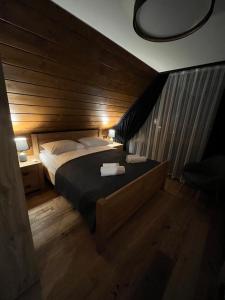 克鲁斯兹考采View & Spa Villa的一间卧室设有一张带木墙的大床