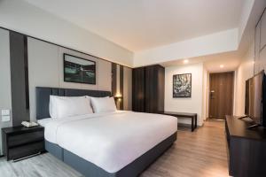 曼谷12 The Residence Hotel & Apartment - SHA的卧室配有一张白色大床和电视。