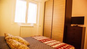 纳维廖河畔切尔努斯科卡塞塔公寓的一间卧室设有一张带电视和窗户的床。