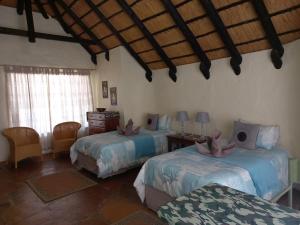奥马鲁鲁罗迪娜野生山林小屋的一间卧室,配有两张床