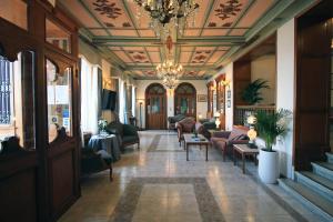 埃尔莫波利斯西瑞尔梅拉斯瑞酒店的大堂设有吊灯、沙发和椅子