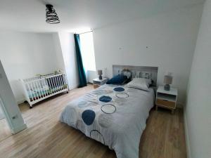 CellesGîte Chez Cheynaud的一间卧室配有一张大床和一张婴儿床。