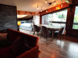 莱孔塔米讷蒙茹瓦Appartement en plein centre du village (6-8 personnes)的客厅配有桌椅和1张床