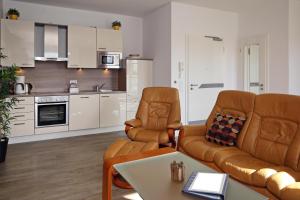 海利根达姆Residenz von Flotow Wohnung 17的客厅配有沙发、椅子和桌子