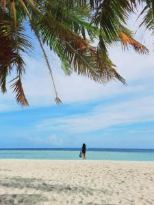 马提威力Mystic Maldives Mathiveri Retreat的站在海滩上看海洋的人