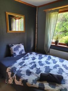 HarmångerSchnieders1German forest B&B的一间卧室配有一张带蓝色棉被的床和窗户。