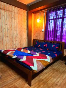 噶伦堡The Sangam Homestay的一间卧室,床上有五颜六色的被子