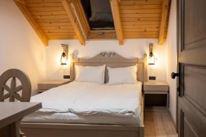 布朗Pension Mama Cozonacilor的卧室配有白色的床铺和木制天花板