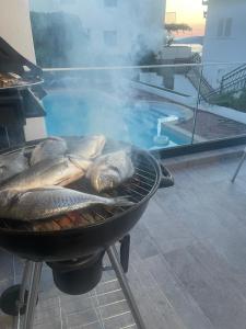 希杰弗朗吉卡Villa A'Mare的鱼在游泳池旁的烤架上烹饪
