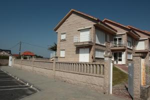 阿兰扎达Desconectaengalicia La Lanzada, a pie de playa的前面有围栏的房子
