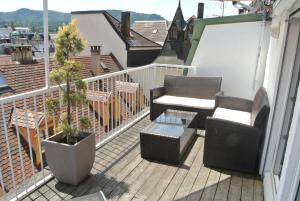 巴登-巴登Esprit-Apart-Hotel的阳台配有两把椅子和一张桌子,种植了植物