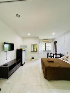 Ban Na PhoWassana Sitdharma Guesthouse的一间大卧室,配有一张床和一台电视