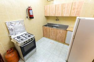 巴哈العييري للوحدات المفروشة الباحة3的小厨房配有炉灶和冰箱
