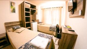 Telêmaco BorbaOpen Hotel的小房间设有两张床和一张书桌