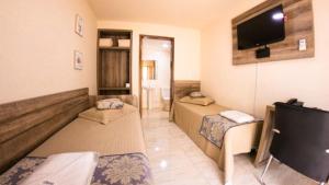 Telêmaco BorbaOpen Hotel的客房设有两张床和一台平面电视。