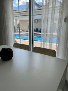 安塔利亚Villa Brothers Kemer的窗口前的白色桌子,带游泳池