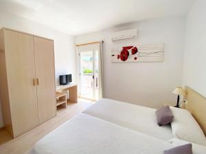 佩尼斯科拉Habitaciones Camping Ferrer的白色的卧室设有白色的床和窗户。