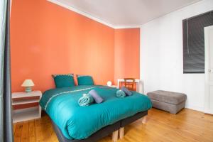 南特Superbe Appartement Calme 85m², à deux pas du Centre的一间卧室配有一张蓝色的床和橙色的墙壁
