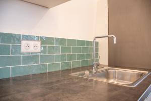南特Superbe Appartement Calme 85m², à deux pas du Centre的厨房配有水槽,墙上铺有绿色瓷砖。
